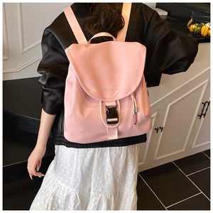 Dettaglio dello zaino in nylon rosa con patta, fibbia nera e cerniera laterale decorativa