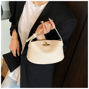 Details einer cremefarbenen Handtasche aus Leder mit goldenem Drehverschluss
