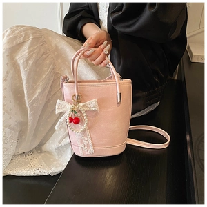 Détail du sac seau en cuir PU rose avec pendentif cerise en dentelle et perles