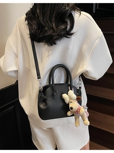 Bolso negro de cuero con grano de lichi en forma de concha y colgante de perro adorable