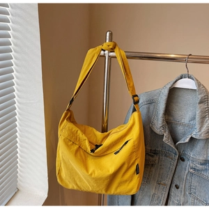 Dettaglio ravvicinato di una borsa a tracolla giallo senape con cerniera e fibbia