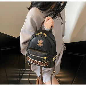 Détail du mini sac à dos noir avec broderie d'ours 'STRONG' et fermetures éclair dorées