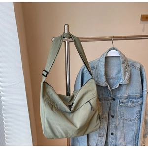 Dettaglio della borsa a tracolla in nylon verde con tracolla regolabile e metallo