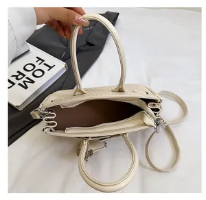 Top view showing the spacious multi-compartment interior and brown lining of the beige handbag