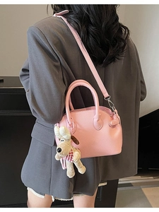 Bolso de mano rosa con textura de lichi, bandolera y colgante de perro de peluche
