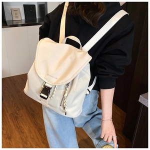 Dettaglio di uno zaino in tela beige con fibbia nera e logo del marchio Honey cute