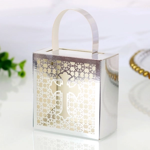 Detailed laser-cut silver cross favor box with intricate lace pattern and top handle
