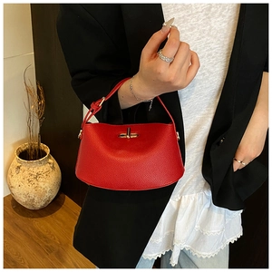Details einer roten Handtasche aus Leder mit Narbung und goldenem Metallverschluss
