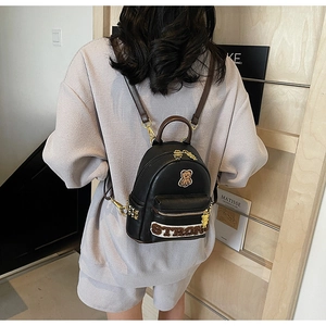 Détail du sac à dos en PU noir avec écusson ours en peluche et broderie STRONG