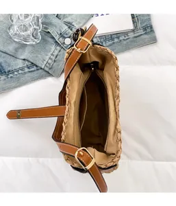 Detail view of woven straw bucket bag with magnetic snap and interior zipper pocket