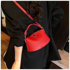 Detail der roten Handtasche aus genarbtem Leder mit goldenem Verschluss als Umhängetasche