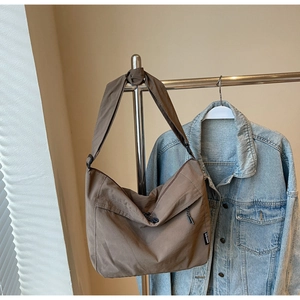 Dettaglio della borsa a tracolla in nylon marrone con tasche e cinturino regolabile