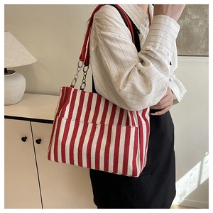 Détail du sac cabas en toile rayé rouge et blanc avec poche avant et bandoulière chaîne
