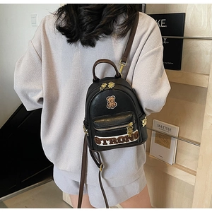 Détail du sac à dos noir en cuir PU avec patch ours en peluche et broderie STRONG