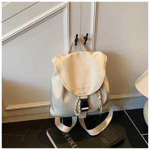 Dettaglio zaino in pelle beige con patta logo Honey Cute e chiusura a coulisse