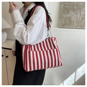 Détail du sac cabas à rayures rouges et blanches avec bandoulières en cuir et chaîne