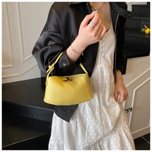 Detail der gelben Crossbody-Tasche aus Leder mit goldener Metall-Drehverschluss-Schließe