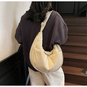 Makroaufnahme der beige Halbmond-Segeltuchtasche mit verstellbarem Riemen und Nähten