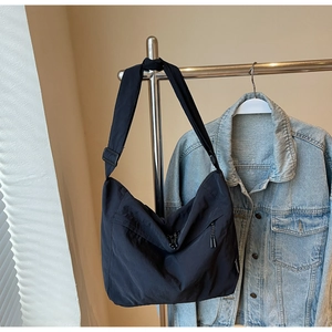 Dettaglio della borsa hobo in nylon nero con tracolla regolabile e chiusura a zip
