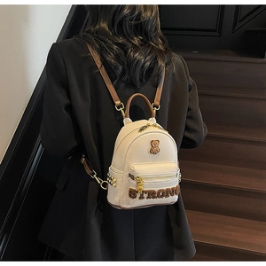 Détail d'un sac à dos blanc en similicuir avec broderie ours et écusson 'STRONG' mode