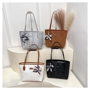 Detailed close-up of textured tote bags in four colors with decorative silk scarves