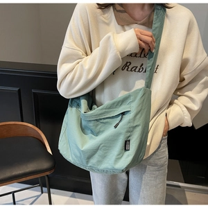 Dettaglio della borsa a tracolla in nylon verde menta con cinturino e zip
