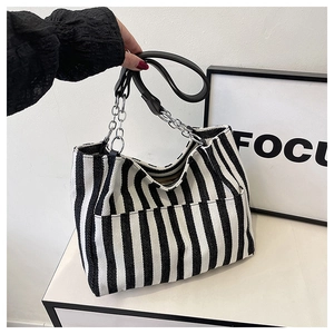 Détail du sac cabas en toile à rayures noires et blanches et chaîne argentée