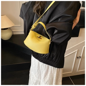 Details der leuchtend gelben Handtasche aus Kieselleder mit goldenem Drehverschluss und Gurt