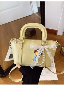 Lime yellow mini Boston bag with lace bow, pearl charm, and adjustable strap