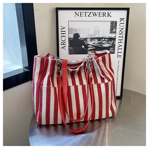Détail du grand sac cabas en toile à rayures rouges et blanches avec sangle en cuir