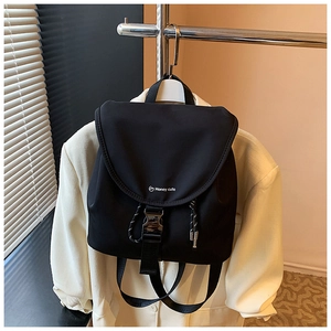 Dettaglio dello zaino in nylon nero con fibbia a scatto e logo Honey Cute stampato