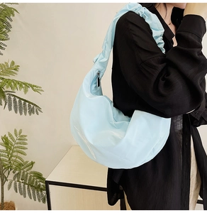 Close-up of light blue nylon hobo bag with a stylish scrunchie shoulder strap detail