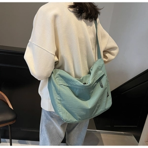 Dettaglio della borsa a tracolla in nylon verde acqua con cinturino regolabile