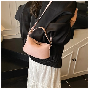 Detail der rosa Lederhandtasche mit Lychee-Muster, goldener Schließe und Trageriemen