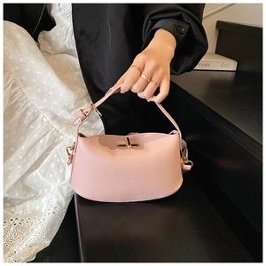 Detailansicht der rosa Handtasche aus Narbenleder mit Drehverschluss und praktischem Griff