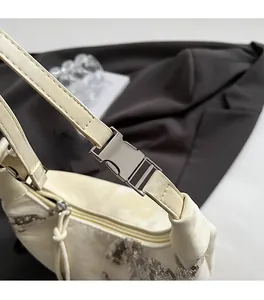 Close-up of premium silver metal hardware and sequined fabric on a beige handbag
