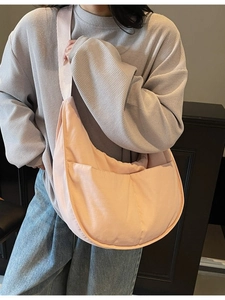 Minimalistische rosa halbmondförmige Canvas-Umhängetasche am Model im sanften Innenraum