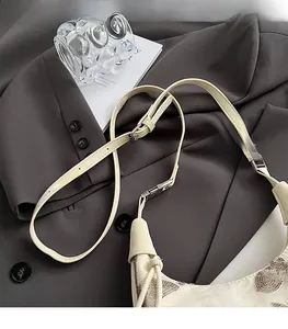 Detailed shot of silver sequins on milk-white bag with metallic hardware buckle