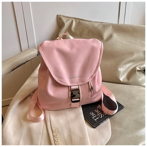 Dettaglio dello zaino in nylon rosa con chiusura a fibbia e tasca su tessuto beige