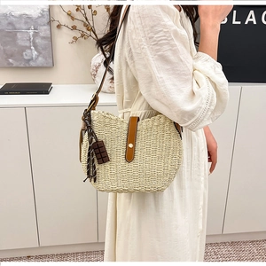 Close-up of beige woven bucket bag with brown leather clasp and polka dot ribbon