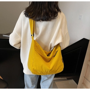 Vista posteriore di una grande borsa a tracolla gialla con ampia tracolla regolabile