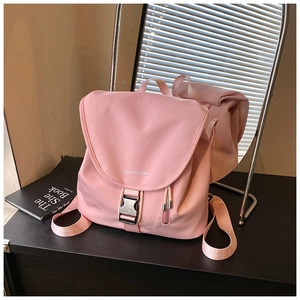 Dettaglio dello zaino rosa in nylon resistente all'acqua con fibbia nera su legno