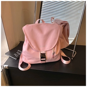 Dettaglio dello zaino in nylon rosa con chiusura a fibbia nera e tasca laterale con zip