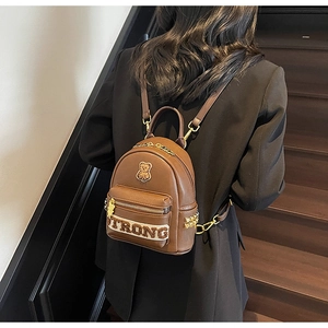 Détail du sac à dos en similicuir marron avec broderie d'ours et rivets dorés
