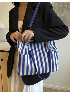 Grand sac cabas en toile rayé bleu et blanc avec poignées en cuir sur mannequin