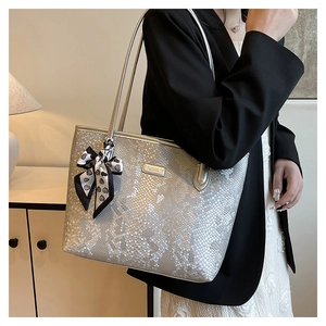 Detailed view of silver snakeskin tote bag with elegant silk scarf and metal logo
