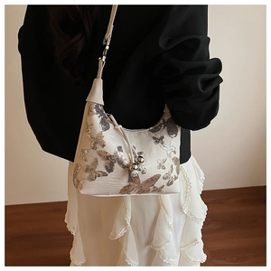 Detail of cream sequin butterfly shoulder bag featuring three silver decorative beads