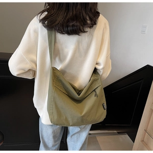 Dettaglio della grande borsa a tracolla hobo verde oliva in nylon con etichetta