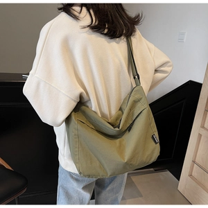 Borsa a tracolla verde oliva in tela con tasca frontale e etichetta logo in tessuto