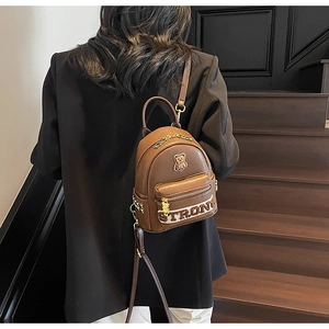 Vue détaillée du sac à dos en similicuir marron avec patch ours mignon et zip doré élégant